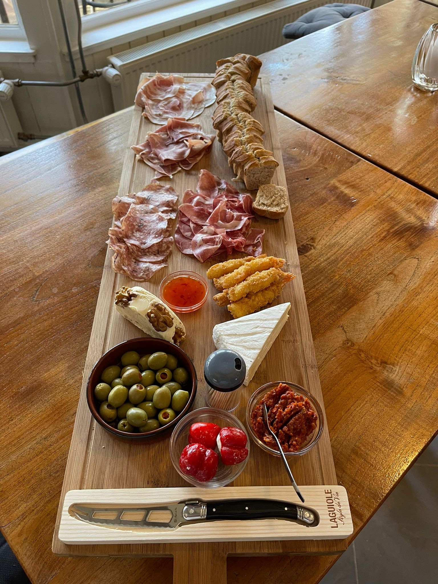 Lange borrelplank met kazen, vleeswaren, olijven en hapjes