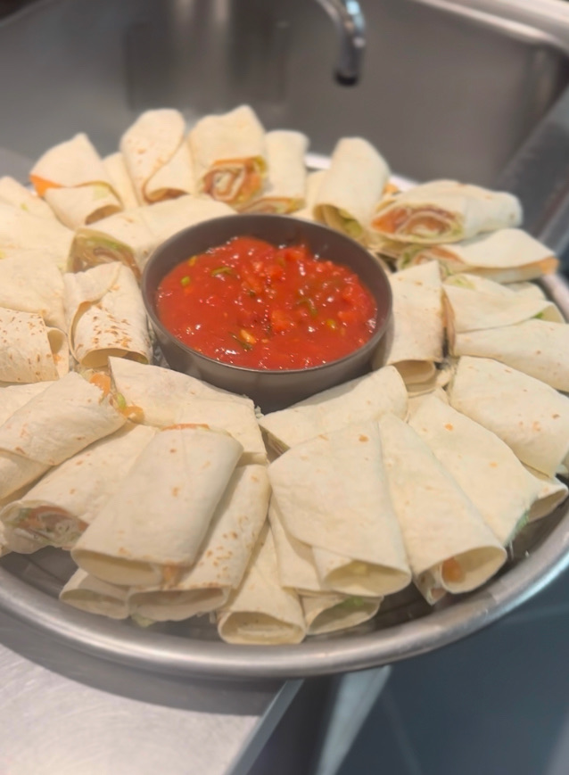 Feestelijke schaal met gevulde wraps en dipsaus